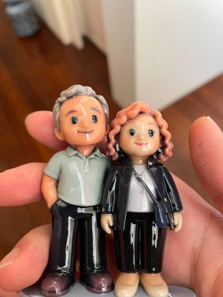 Close-up of a couple figurine standing side by side, held in a hand