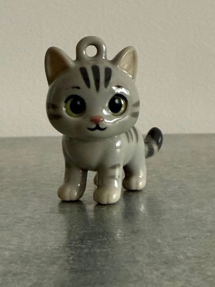 Grey tabby kitten keychain standing on a stone counter